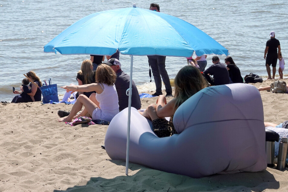 Zahlreiche Menschen genieße den Sonnenschein am Elbstrand Övelgönne.