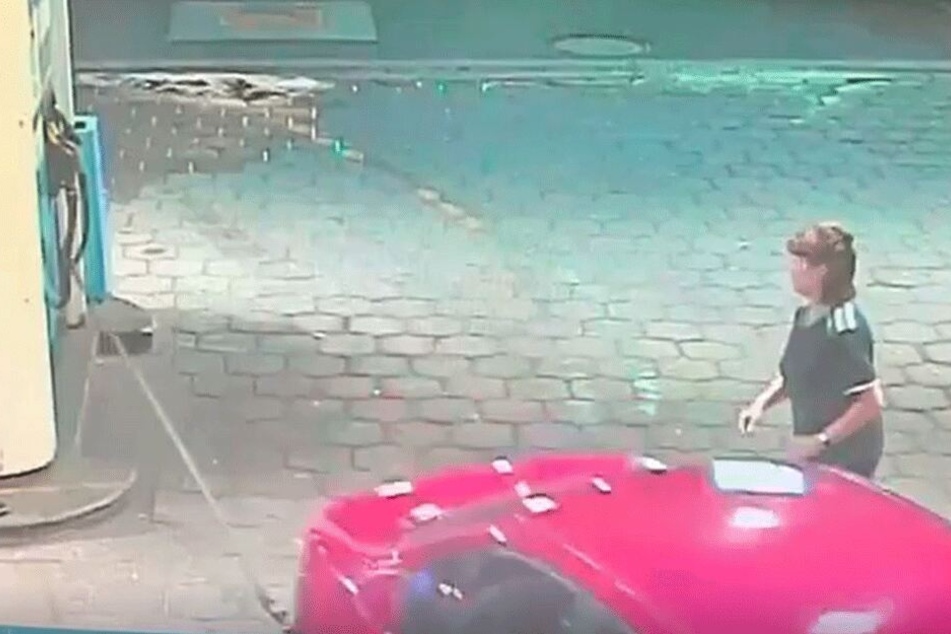 Mit Vollgas rast der BMW mit steckender Zapfpistole davon. Der Schlauch wird abgefetzt, Diesel spritzt in einer hohen Fontäne heraus.