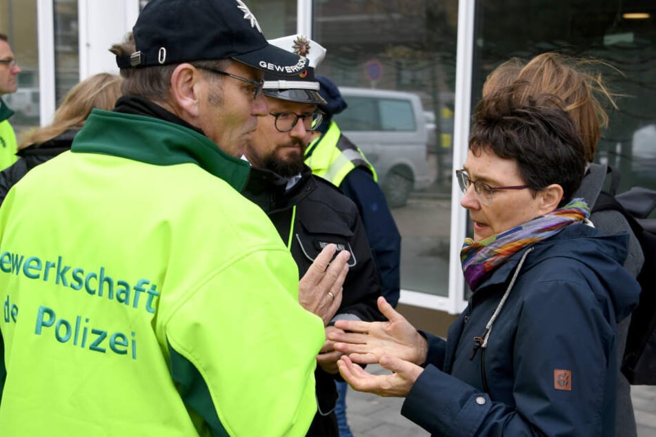 Finanzministerin Monika Heinold (Bündnis 90/Die Grünen, r) spricht vor dem Landesparteitag der Grünen mit demonstrierenden Polizisten.