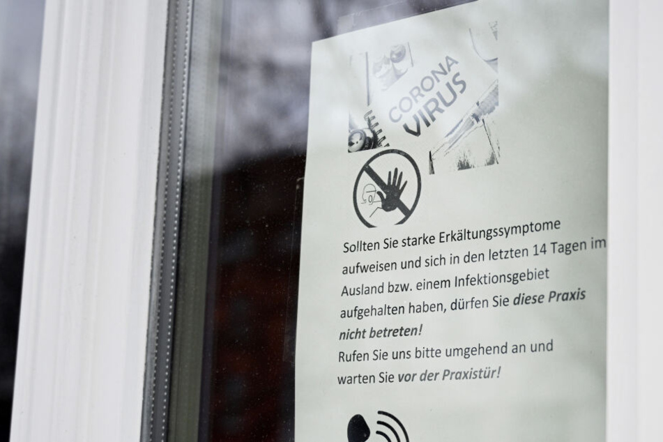 In Thüringen hängt ein Warnschild vor dem Virus in einer Arztpraxis.