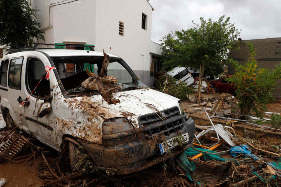 Autowracks stehen nach dem Unwetter an einer Hauswand.