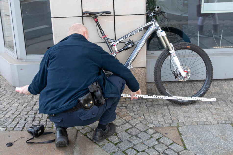 Ein Beamter nimmt Messungen am Unfall-Rad vor.