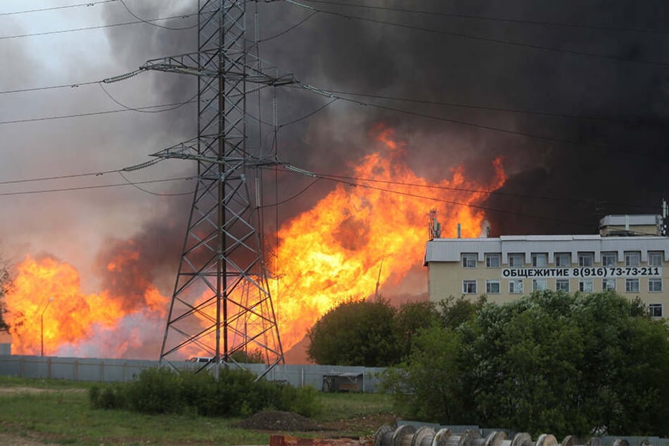 Schwarzer Rauch und Flammen steigen in der Nähe eines Wärmekraftwerks auf.