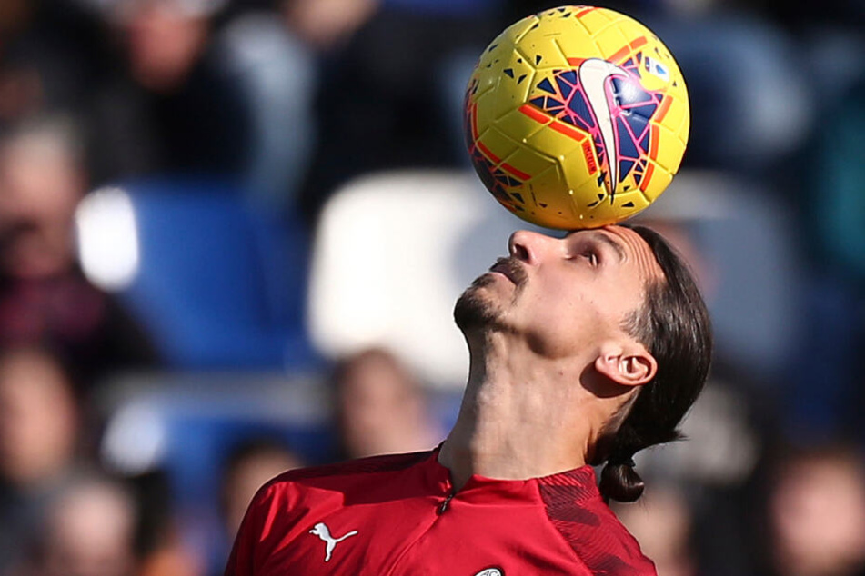 Zlatan Ibrahimovic vom AC Mailand (M) balanciert einen Ball auf dem Kopf beim Aufwärmen vor dem Spiel.