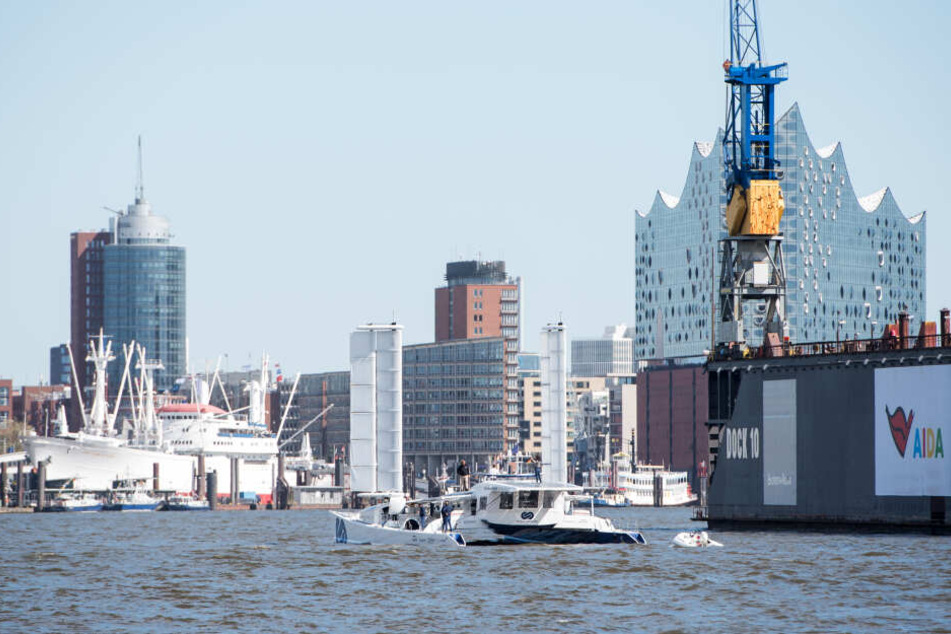 Das wasserstoffbetriebene Elektroboot "Energy Observer" läuft in den Hamburger Hafen ein. Im Hintergrund ist die Elbphilharmonie zu sehen.