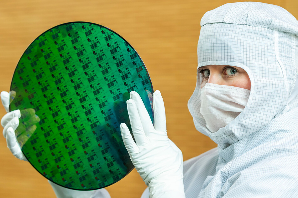 Eine Auszubildende der "Globalfoundries"-Chipfabrik in Dresden präsentiert einen "Wafer", auf dem Mikro-Chips hergestellt werden.