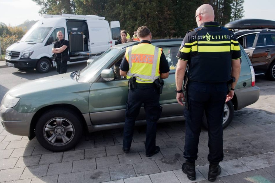 Polizisten aus den Niederlanden und Deutschland kontrollieren ein Auto bei einer Großkontrolle.