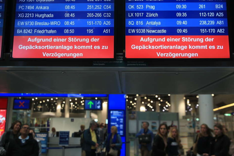 Hinweistafeln im Düsseldorfer Flughafen zeigen an, dass es aufgrund einer Störung der Gepäcksortierungsanlage zu Verzögerungen kommt.
