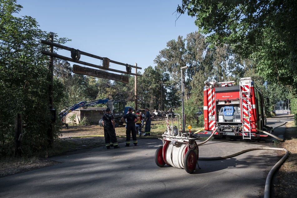 Einsatzkräfte der Feuerwehr kontrollieren, dass alle Glutnester an der Westernstadt ausgemerzt sind.