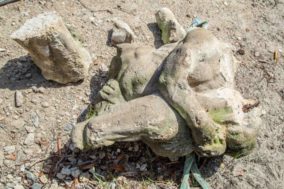 Die ersten Sandstein-Teile der Herkules-Figur sind geborgen. Zu sehen ist der muskulöse Oberkörper mit rechtem Arm und Keule.