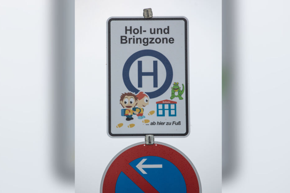 Ein Verkehrsschild weist eine Hol- und Bringzone für Eltern aus, die morgens ihre Kinder mit dem Auto zur einer nahe gelegenen Schule bringen. Den Rest des Weges müssen die Kinder zu Fuß zurücklegen.
