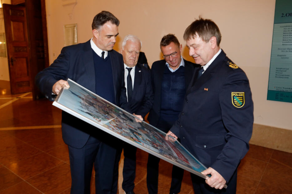 Die Delegation von RB Leipzig, Direktor Ulrich Wolter, Sicherheitschef Uwe Matthias, Sportdirektor Ralf Rangnick (v.l.n.r.), überreichte dem scheidenden Polizeichef ein Plakat mit dem Slogan "Bernd Merbitz - drei Mal aufgestiegen".