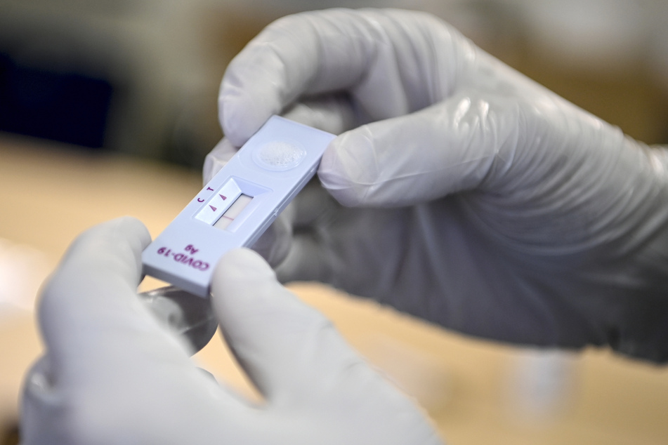 Ein medizinischer Mitarbeiter hält einen negativen SARS-CoV-2-Antigentest, in einem Corona-Antigen-Schnelltestzentrum in der Hand.