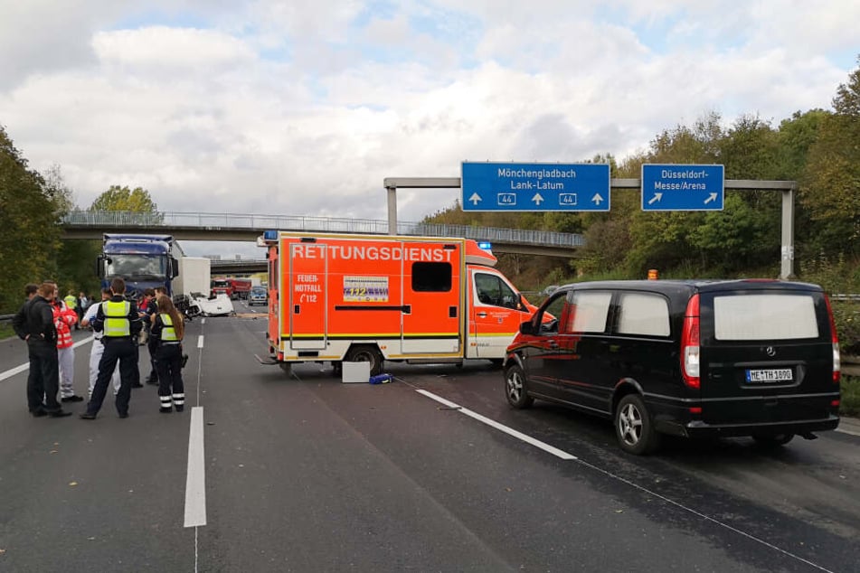 Polizisten und Rettungskräfte stehen neben einem Krankenwagen und einem Leichenwagen auf einer Fahrbahn der Autobahn A44 in Düsseldorf.