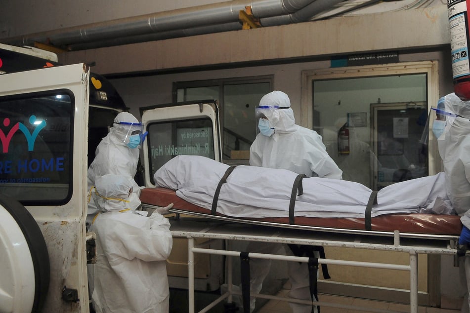 In Schutzkleidung gekleidete Gesundheitshelfer transportieren den Leichnam eines an einer Nipah-Virusinfektion Verstorbenen. (Archivfoto)