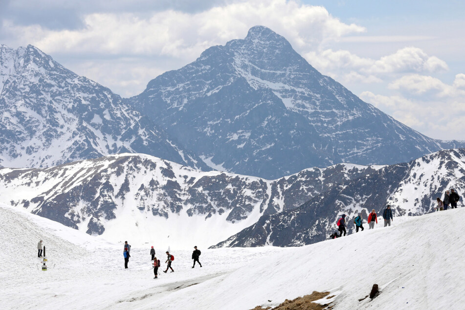 Touristen sind im schneebedeckten Tatra-Gebirge unterwegs, nachdem alle Routen im Tatra-Nationalpark wieder für Besucher geöffnet wurden.