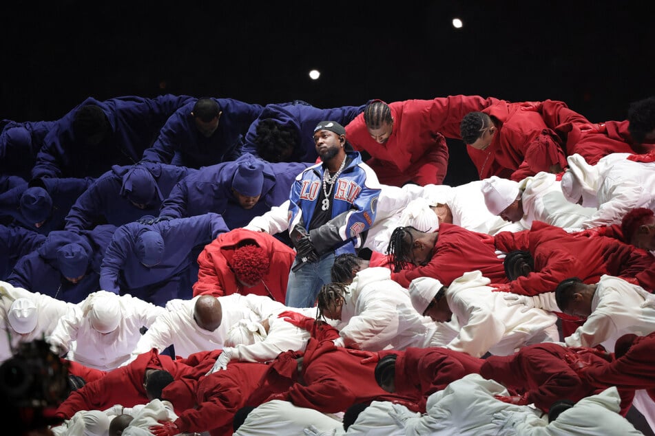 Kendrick Lamar performs at Super Bowl LIX as dancers dressed in red, white, and blue coalesce into an American flag formation.