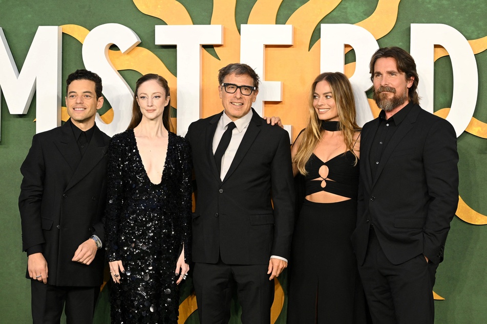 From l to r: Rami Malek, Andrea Riseborough, David O. Russell, Margot Robbie, and Christian Bale pose at the premiere for the murder-mystery film Amsterdam.