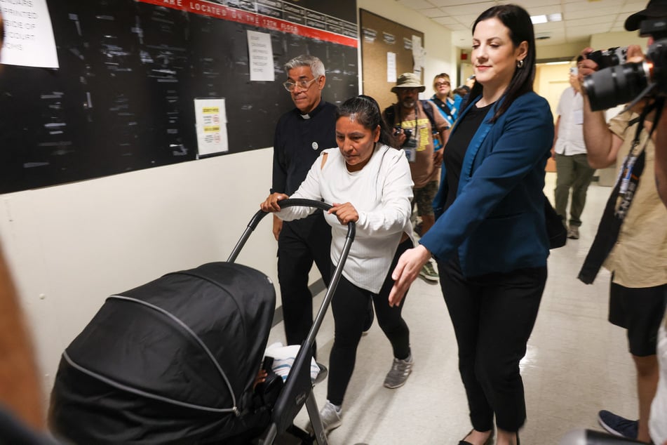 A woman and child exit immigration court as Federal agents patrol the halls at the Jacob K. Javitz Federal Building on July 22, 2025 in New York City.