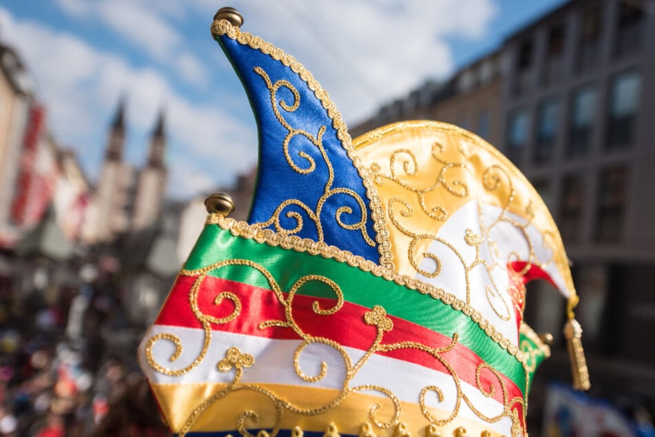 Ein Karnevalist trägt beim Faschingsumzug eine bunte Narrenkappe (Symbolfoto).