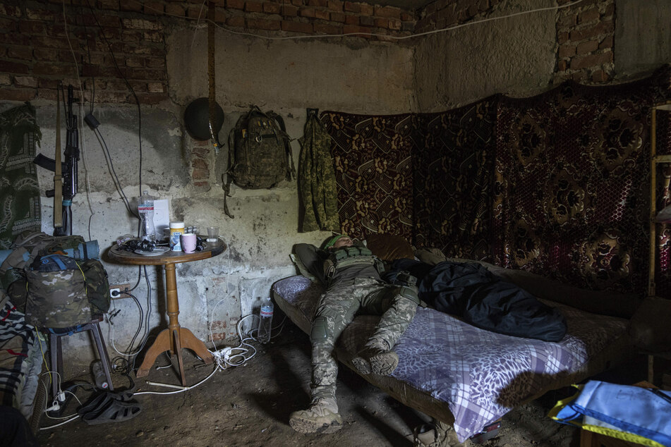 Ein ukrainischer Soldat ruht auf seinem Bett in einem Luftschutzkeller an der Frontlinie in der Region Charkiw.