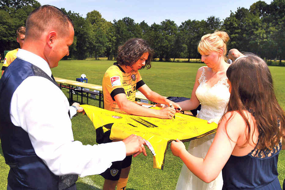 Nach dem Mannschaftsfoto signierten die Spieler, hier Matthäus Taferner, ein großes Dynamo-Trikot für Cindy und Robin Kühne.