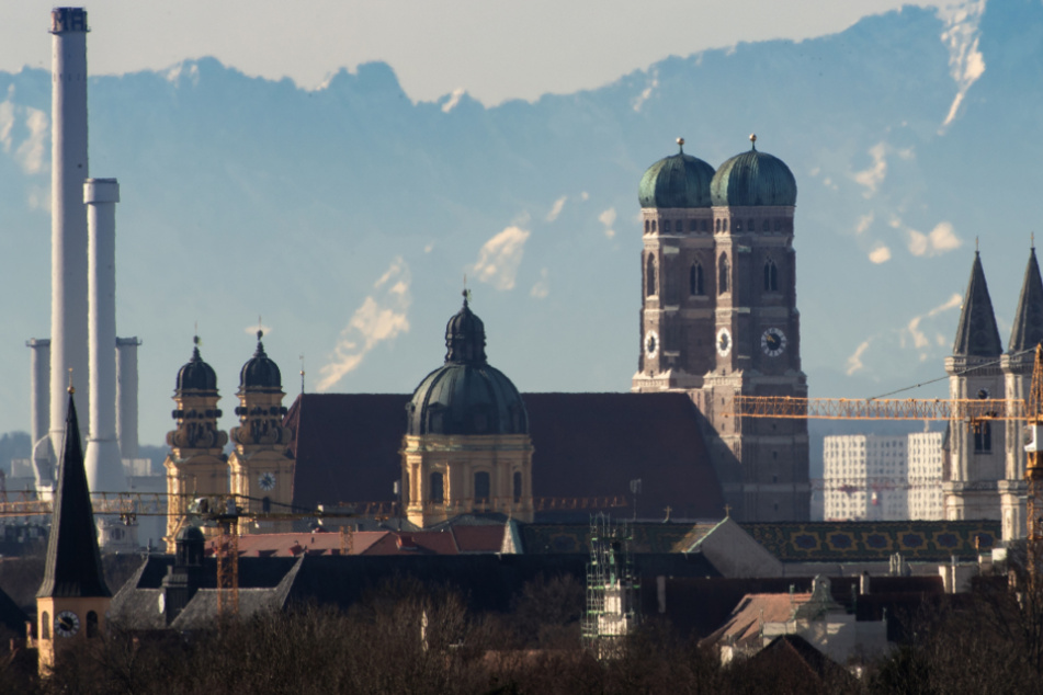 Die Skyline der bayerischen Landeshauptstadt vor der Kulisse der Alpen.