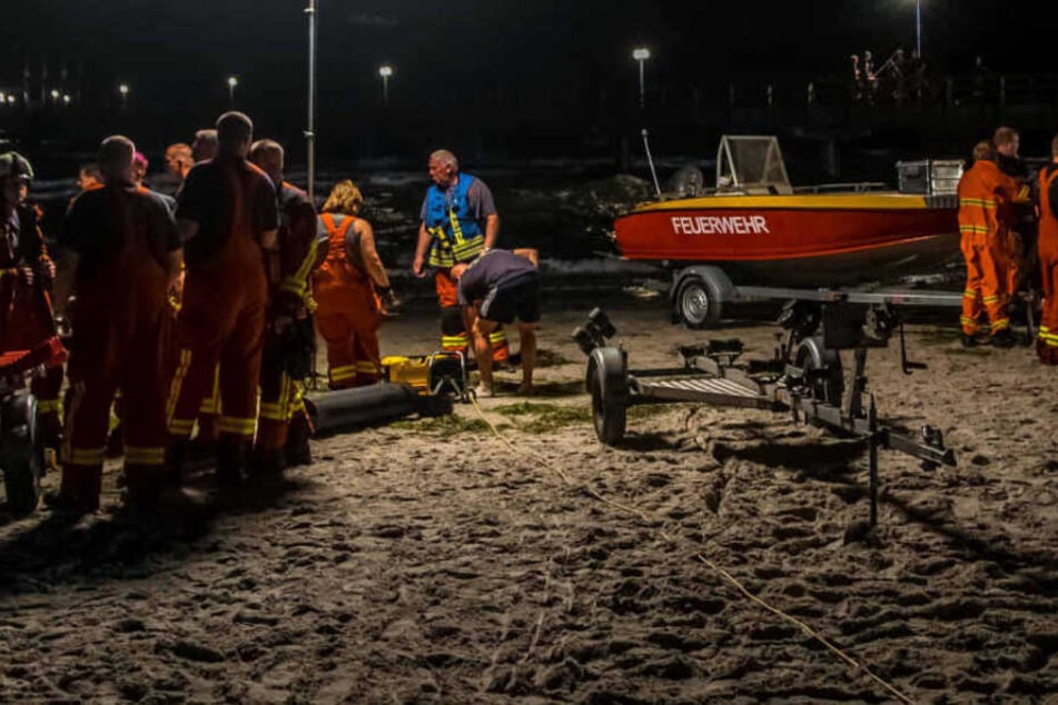 Rettungskräfte planen an einem Ostseestrand ihren Einsatz.
