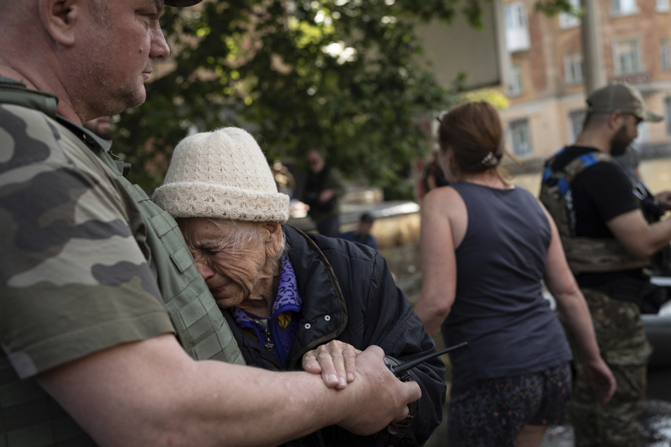 Eine Frau weint, als sie aus einem überfluteten Viertel evakuiert wird.