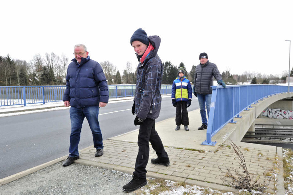 Über die Brücke geht es, danach reißt der Fußweg ab: Jürgen Leistner (67, CDU), Jonas (17), Benjamin (10) und Papa Holger Schmidt (50, v.l.) an der Shakespearestraße in Kleinolbersdorf.