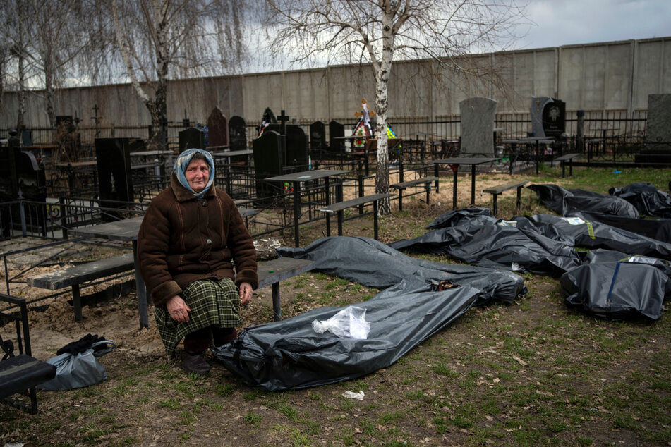 Nadija Trubtschaninowa sitzt auf einem Friedhof neben einem Plastiksack, der die Leiche ihres Sohnes Wadym enthält, nachdem er am 30. März von russischen Soldaten in Butscha getötet wurde.