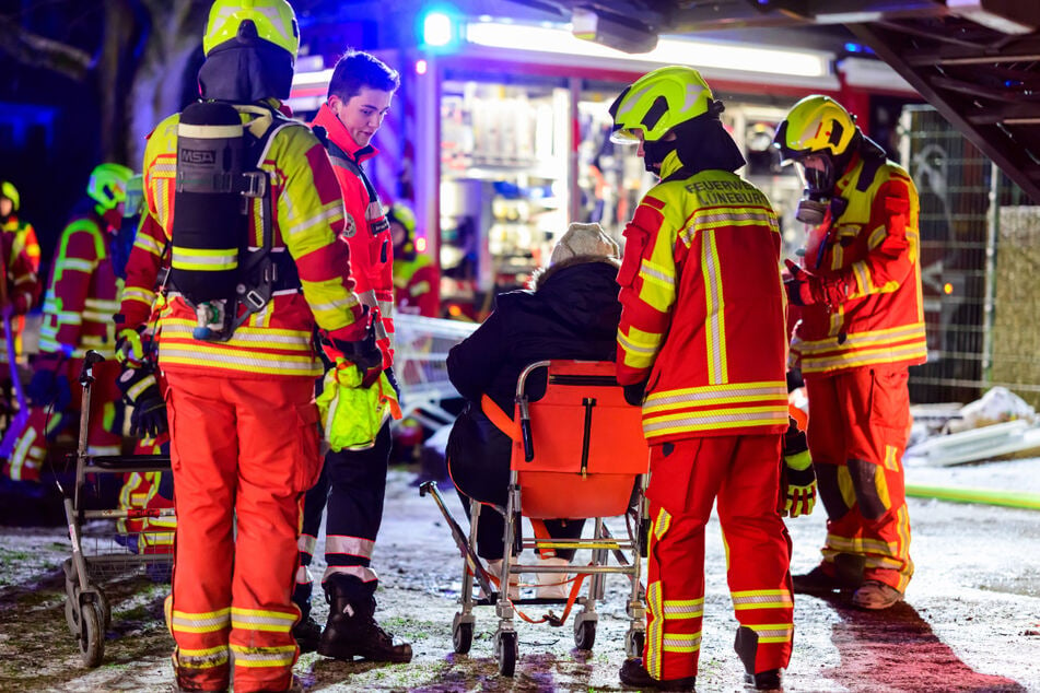 Feuerwehrleute kümmern sich um die Bewohner des Hauses.