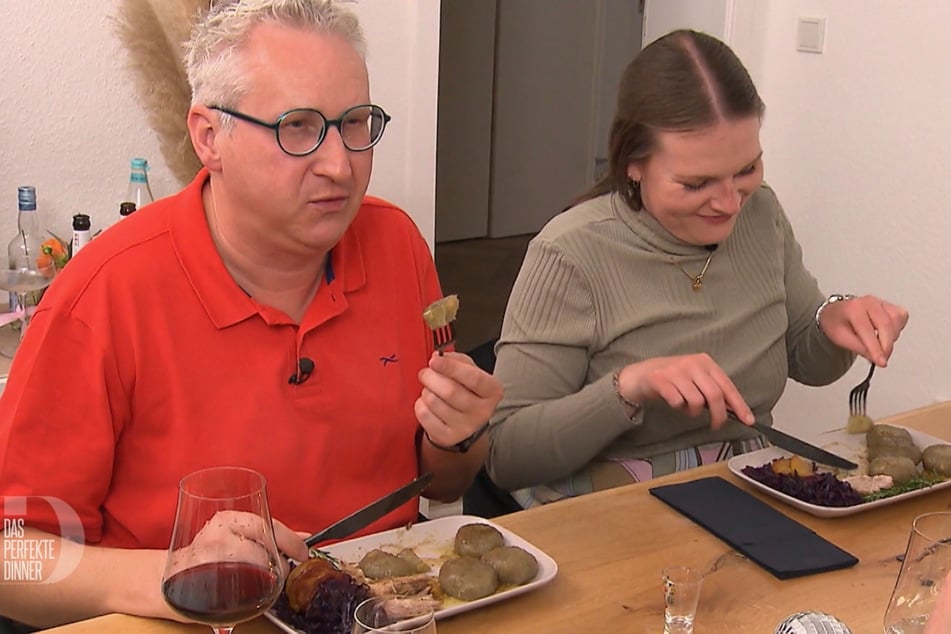 Axel (49) und Caro (27) wagen sich an die schwarzen Klöße, die jedoch nicht mit ihrer "gummiartigen" Konsistenz überzeugen können.