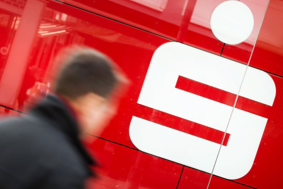 Ein Mann geht an einer Filiale der Sparkasse vorbei (Symbolbild).