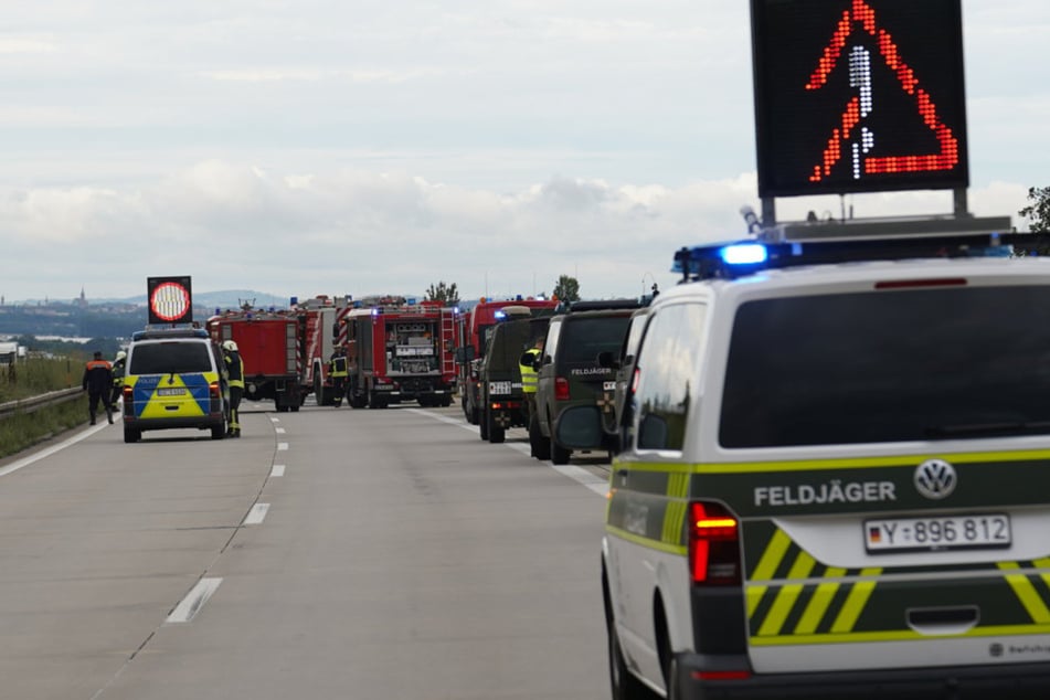 Eine Kolonne der Bundeswehr hielt am Brandort. Feldjäger unterstützen die Polizei dabei, die Fahrbahn abzusperren.