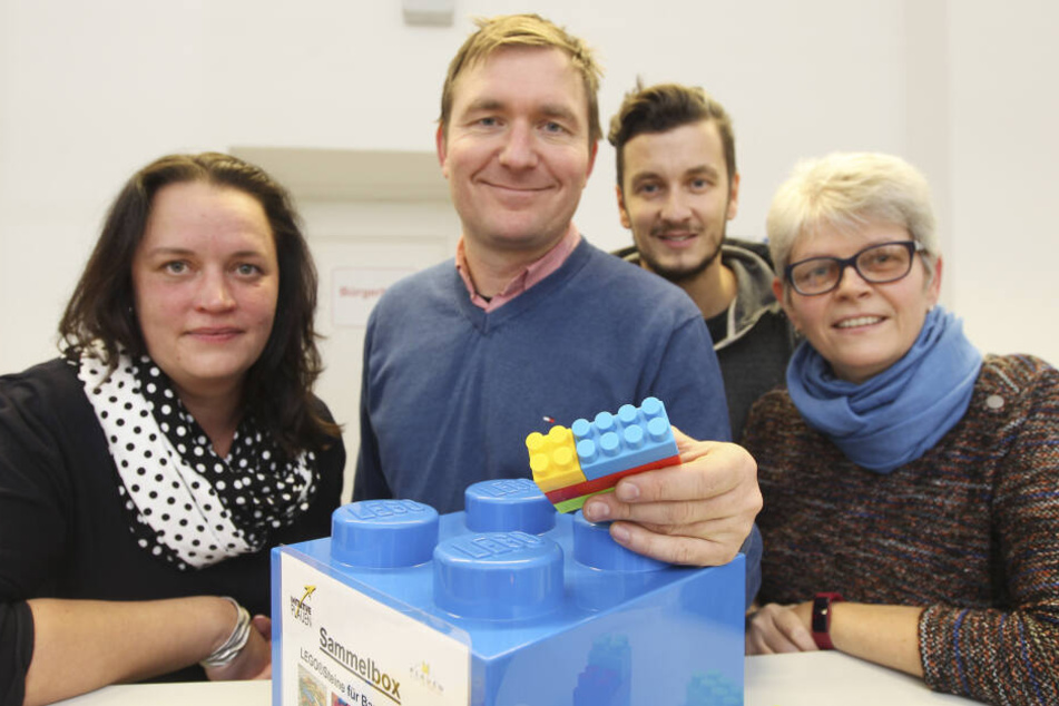 Jana Richter-Wehnert von der SBW Vogtlandkreis GmbH, Projektinitiator Rico Kusche, Bürgerbüro-Mitarbeiter David Biller und Behindertenbeauftragte Heidi Seeling (v.l.) mit einer Sammelbox für Legosteine.