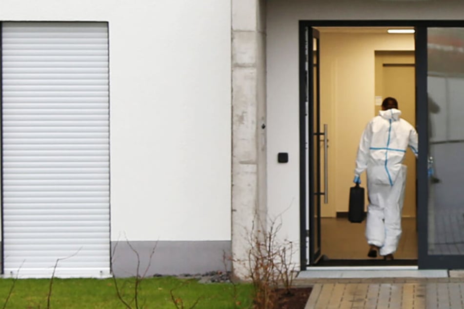Ein Ermittler der Polizei betritt den Eingang des Hauses in der Josef-Dinges-Straße.