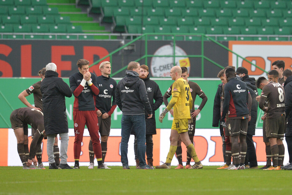 Die Spieler von Pauli um Trainer Timo Schultz (M) stehen nach dem Spiel auf dem Rasen.