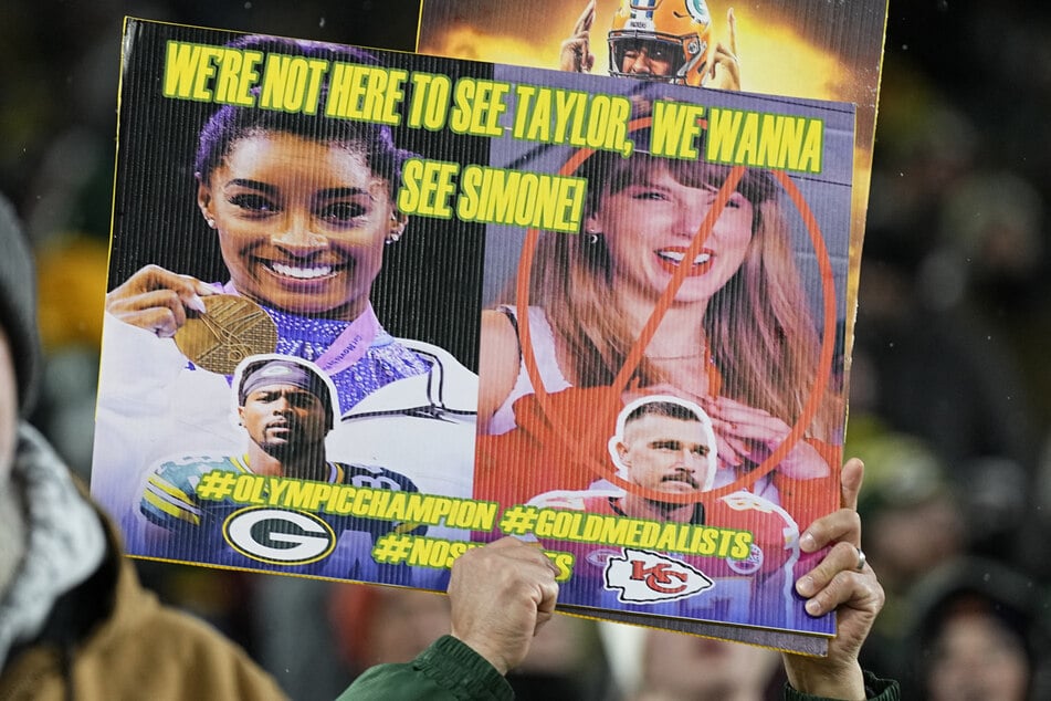 A Green Bay Packers fan holds up a sign referencing both gymnast Simone Biles and singer Taylor Swift prior to the game against the Kansas City Chiefs at Lambeau Field.