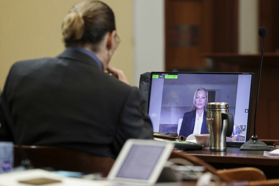 Depp watches Moss as she testifies that the actor never pushed or shoved her down a flight of stairs during their relationship.