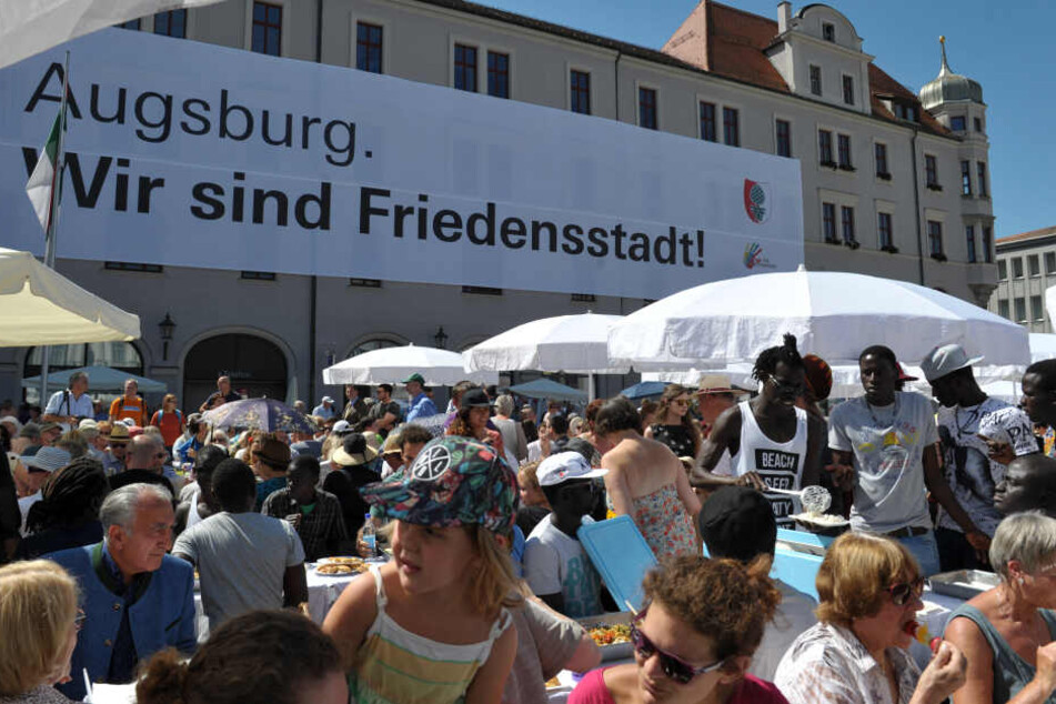 Besucher des Friedensfestes versammeln sich am zu einer gemeinsamen Friedenstafel. (Archivbild)