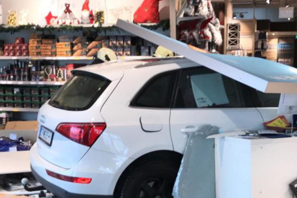 Ein Auto steht im Inneren einer Filiale eines Einrichtungshauses unter Trümmern