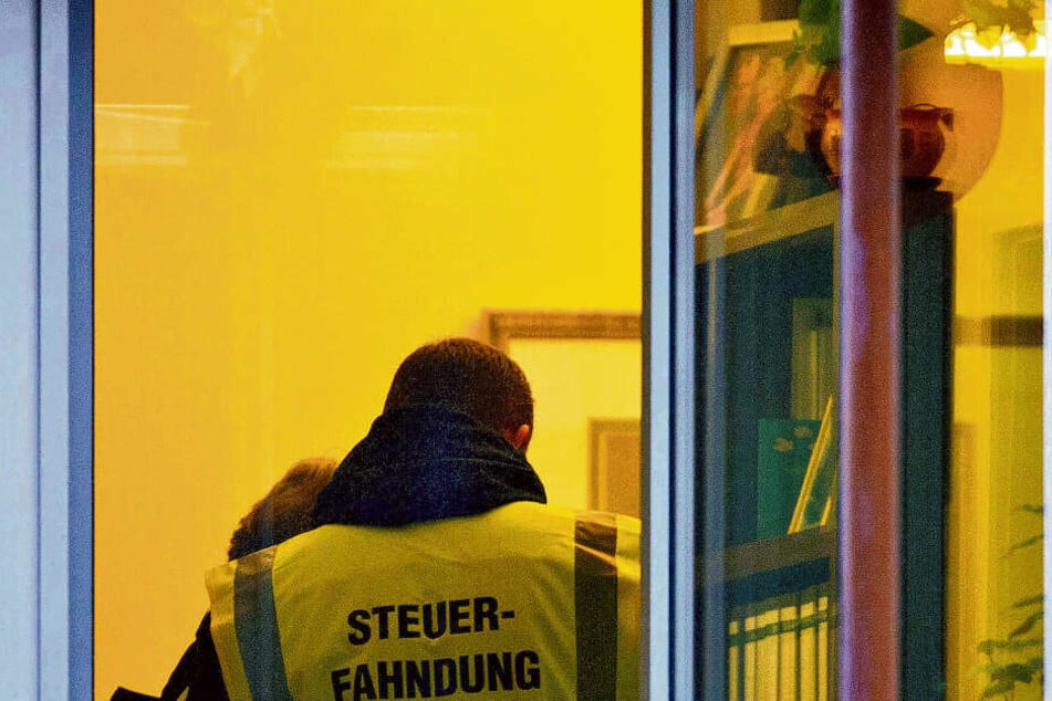 Ein Steuerfahnder, fotografiert bei einer Hausdurchsuchung.
