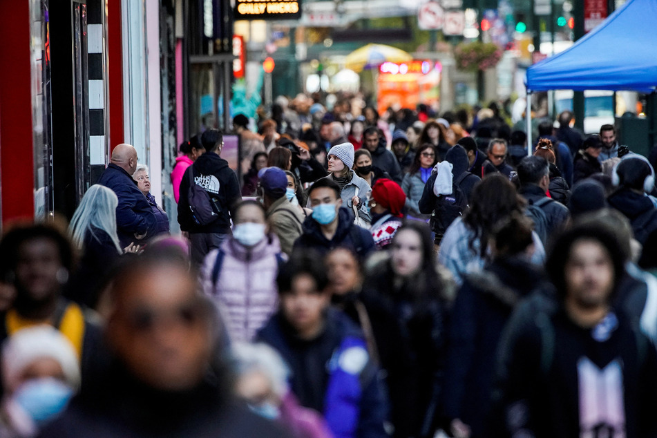 People walk down a crowded street in Manhattan as the world's population is projected to reach 8 billion.