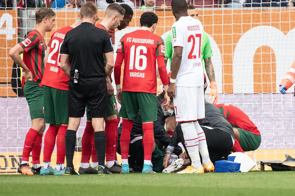 Sanitäter kümmerten sich auf dem Rasen um den verletzten Augsburger Spieler Iago.