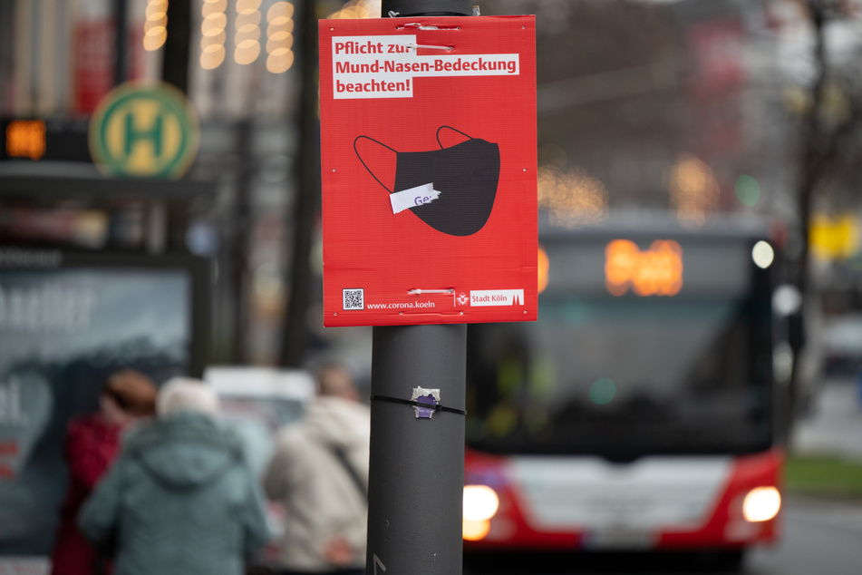 Ein Schild weist in der Rheinmetropole Köln auf das Tragen von Schutzmasken hin: "Pflicht zur Mund-Nasen-Bedeckung beachten".