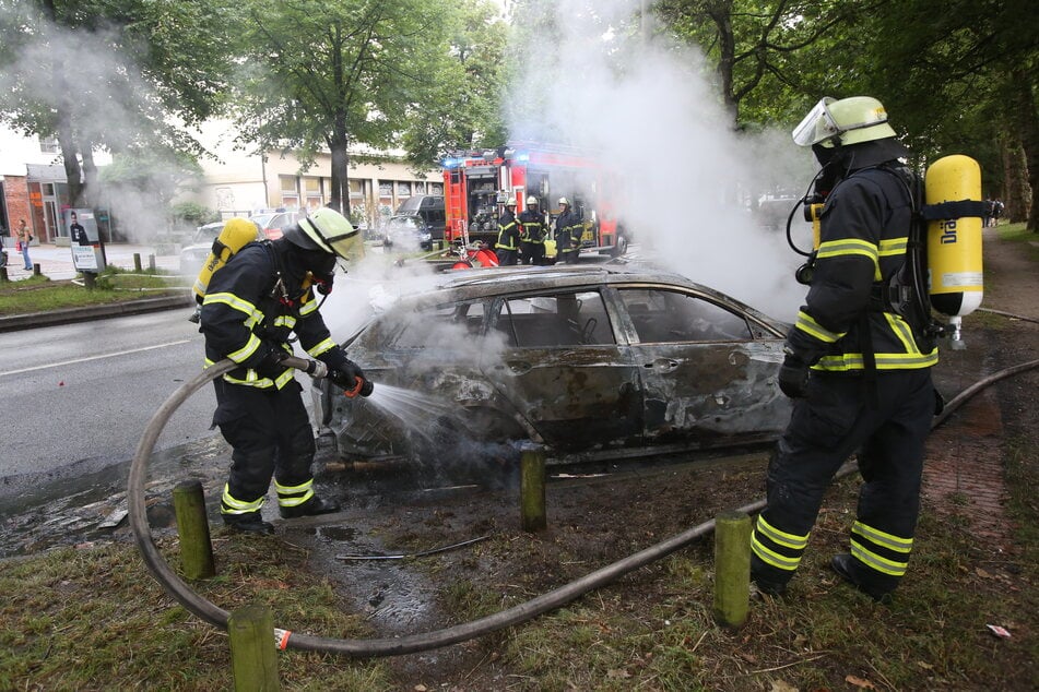 Feuerwehrleute löschen in Altona ein brennendes Auto.