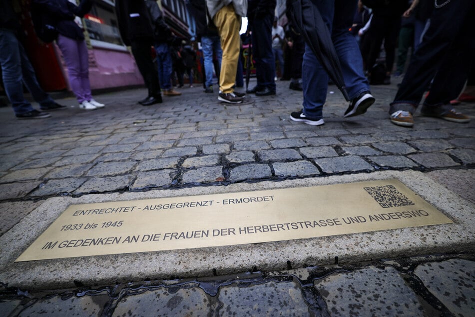 Die Gedenkplatte liegt nach der Enthüllung vor dem Eingang zur Herbertstraße an der Reeperbahn. Die geprägte Bordsteinkante zum Gedenken an die Sexarbeiterinnen zur NS-Zeit wurde durch die Initiative "Lebendiges Kulturerbe St. Pauli e.V." und "St. Pauli Kirche" ermöglicht und verlegt.