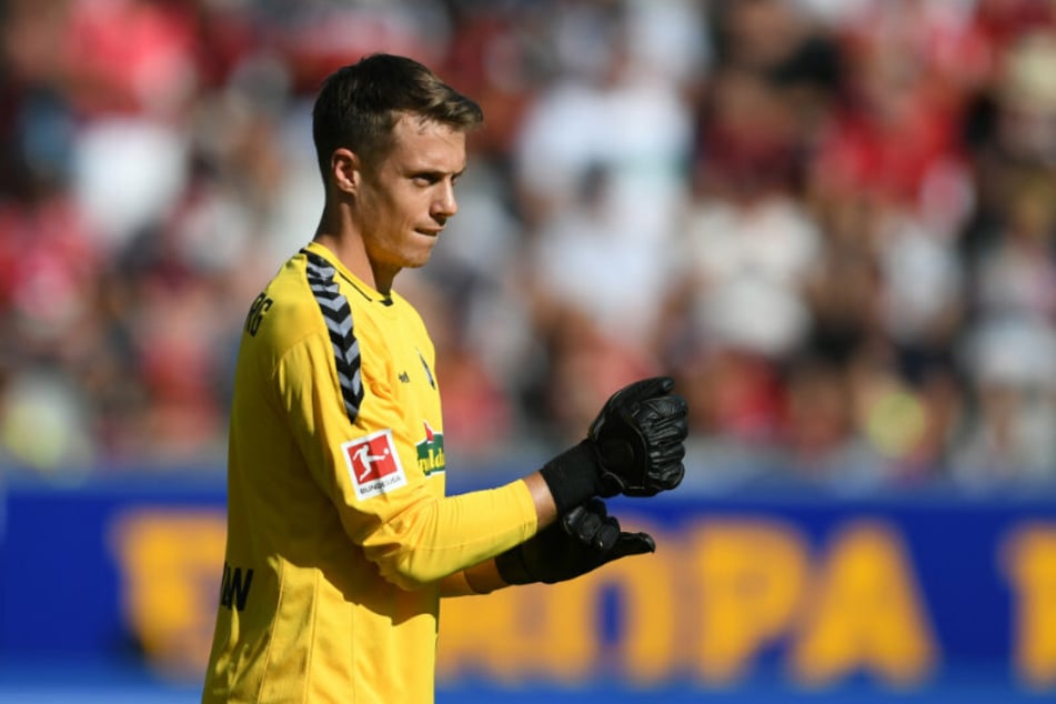 Torwart Alexander Schwolow (28) vom SC Freiburg schließt seine Torwarthandschuhe. (Archivbild)
