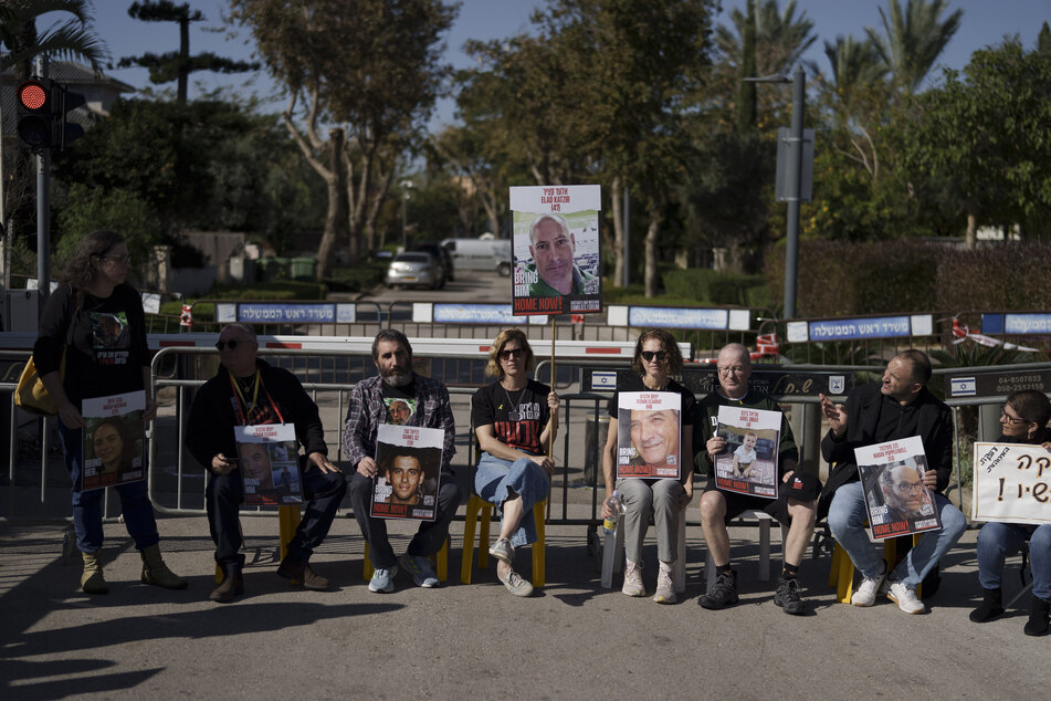 Angehörige und Freunde von Geiseln sitzen auf einer Straße vor dem Privathaus des israelischen Ministerpräsidenten Netanjahu in Caesarea.